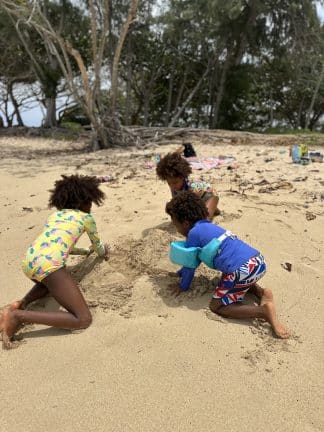 Kids playing on sand during camping trip wearing bright bathingsuits