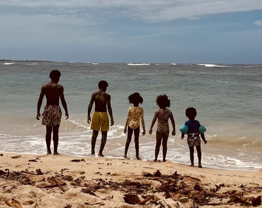 5 kids overlooking the edge of a blue gray lake